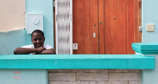 Boy standing outside and leaning against a wall